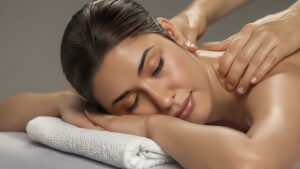 Mujer boca abajo recibiendo masaje en la espalda